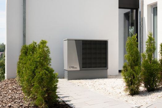 Binnenopgestelde warmtepomp zonder buitenunit in een modern appartement met technische kast en geveldoorvoer