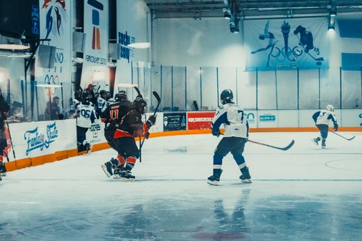 Volle ijshal tijdens ijshockey olympische winterspelen 2026 met spelers in actie en scorebord op de achtergrond