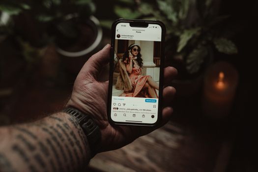 Smartphone met Instagram-feed naast nieuwsberichten over online opsporing en sociale media