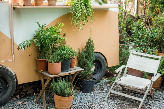 Sfeervol ingerichte kleine patio tuin met compacte tuinbank, planten in potten en warme buitenverlichting